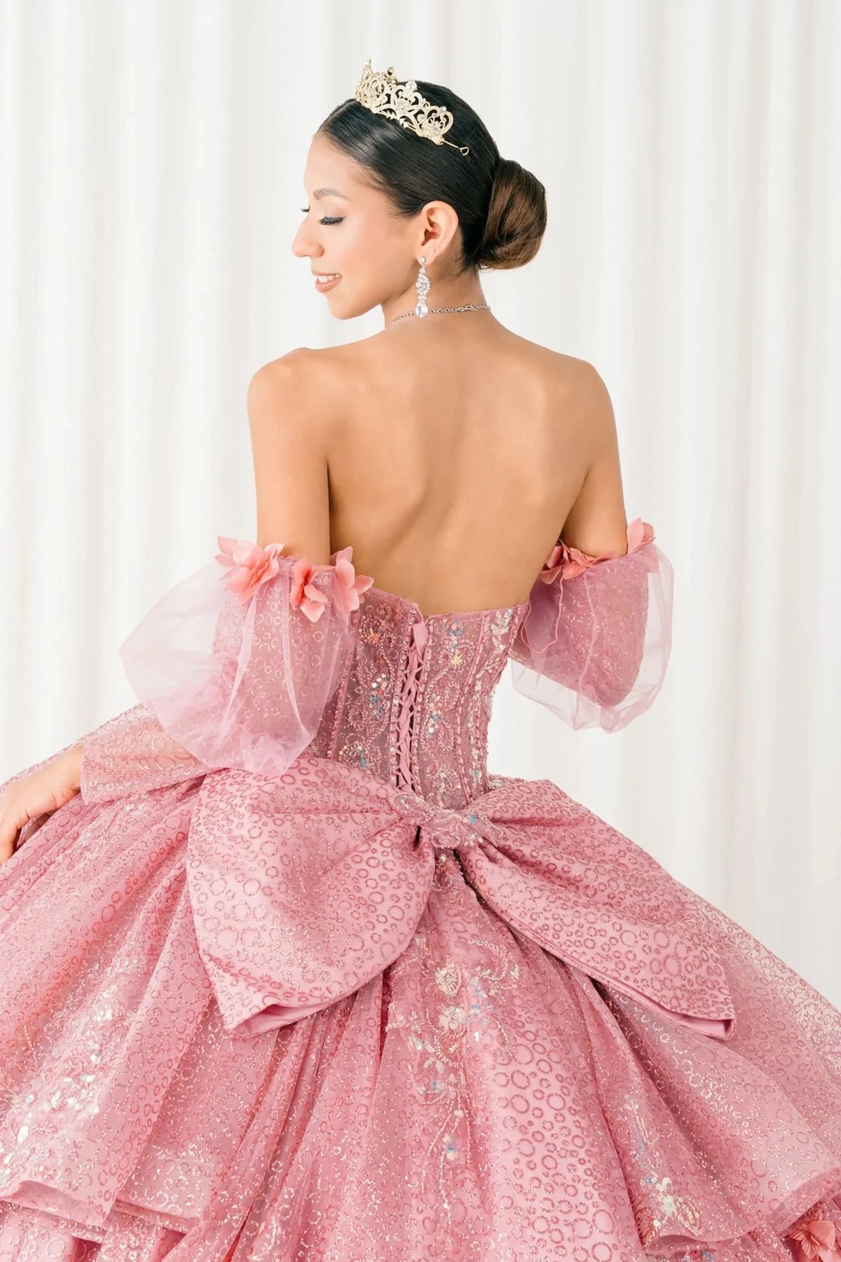 Textured details appear across close-up Dusty Rose quinceañera ball gown with off shoulder tulle sleeves, sweetheart sequin bodice.