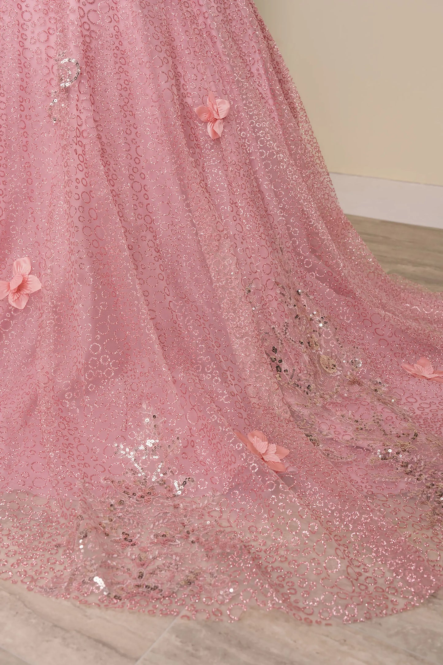 Close up view of Dusty Rose mini quince ball gown with glitter floral embroidered bodice, full skirt, lace up back, oversized bow, and sheer lace gloves