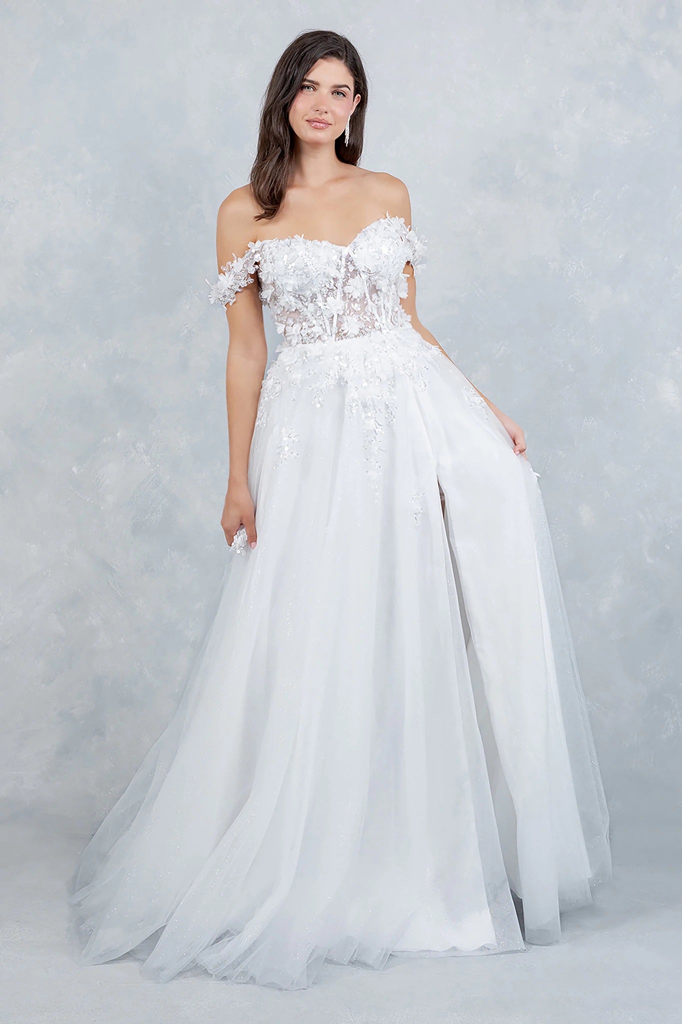 Woman wearing a white strapless gown with floral lace details on a light gray background