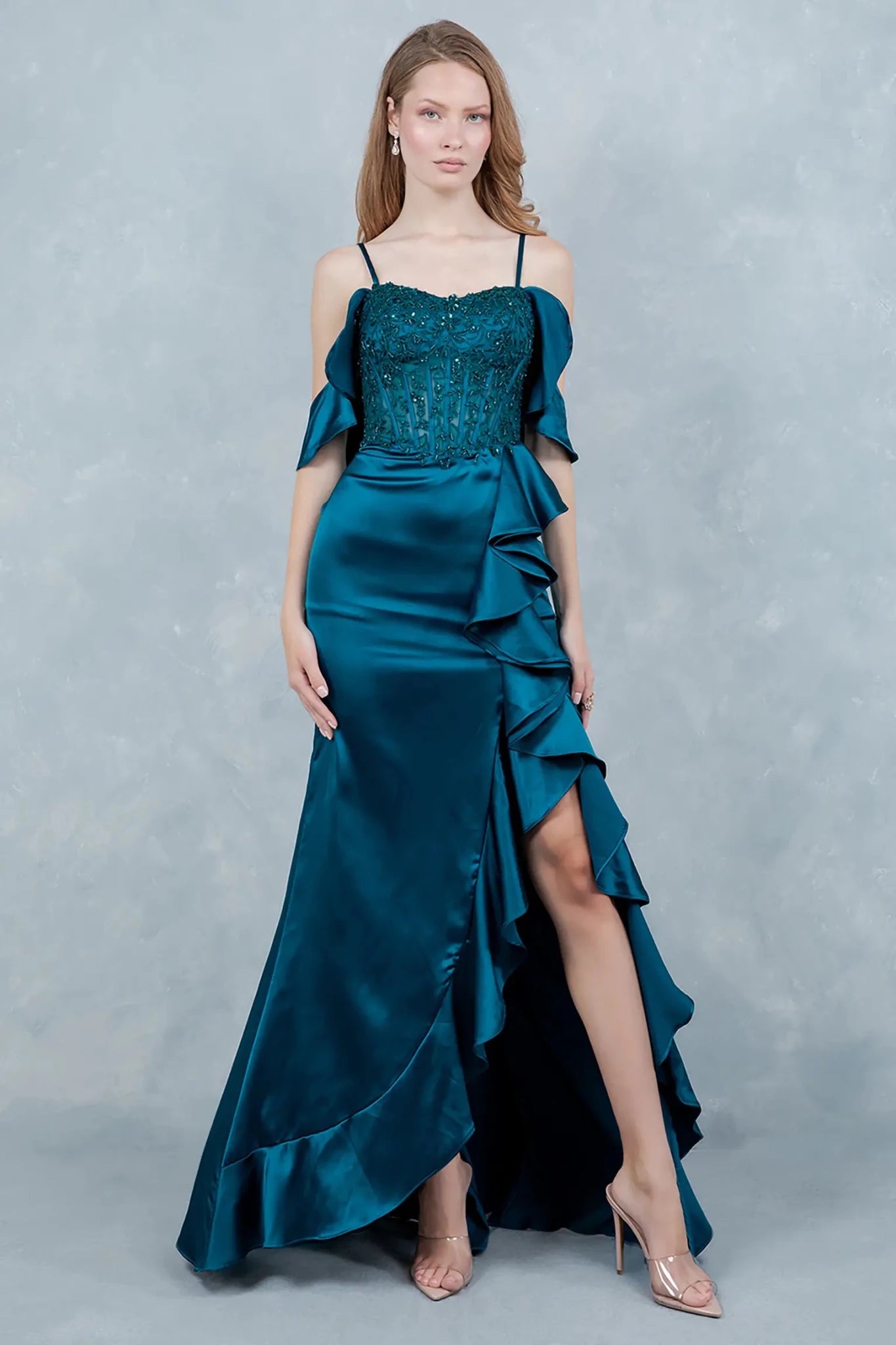 A full-length view of a woman wearing blue formal dress with a graceful train.