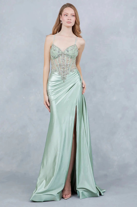 A full-length view of a woman wearing sage formal dress with a lace-up corset and train.