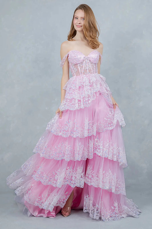 A full-length view of a woman wearing pink fairytale dress with a lace-up corset and layered skirt.