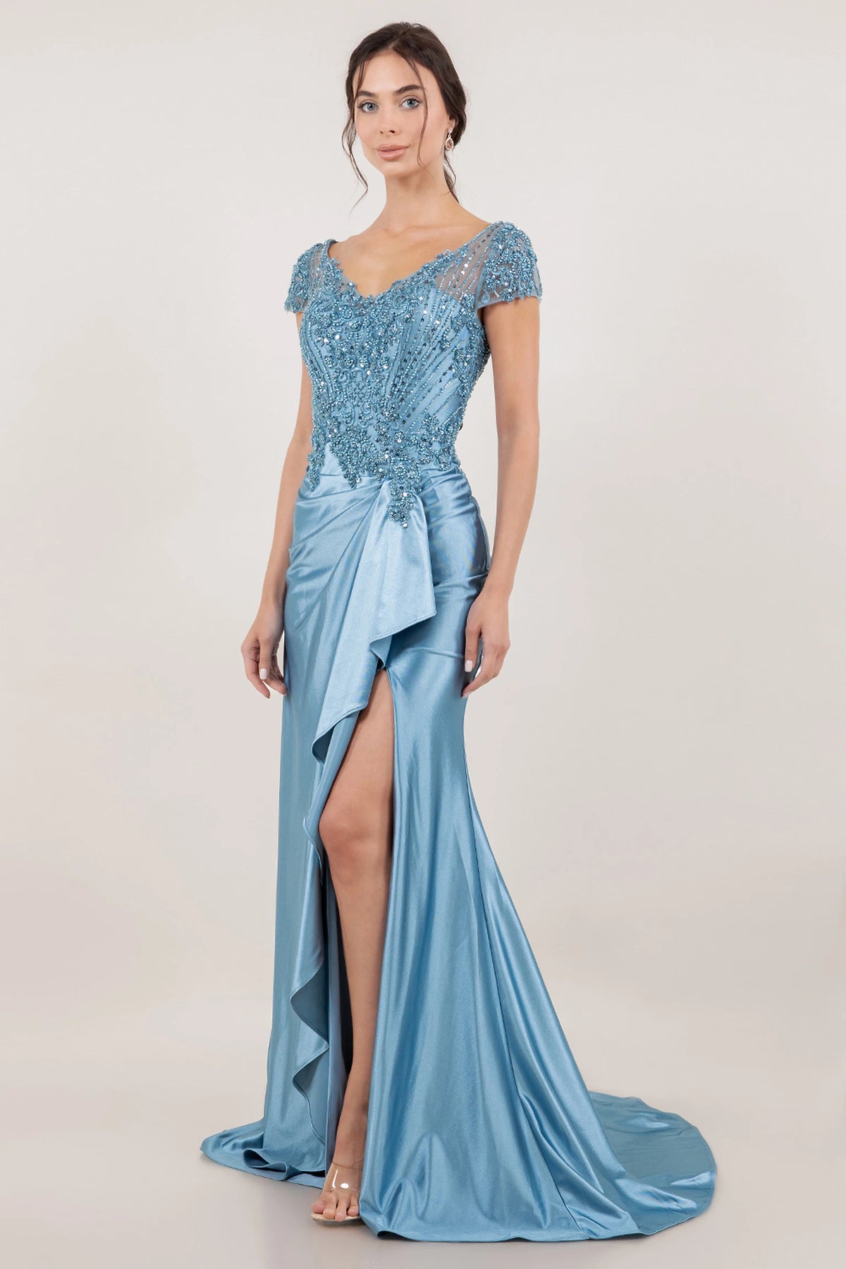 A dramatic Dusty Blue mother of the bride dress view reveals the front slit beside its draped ruffle.