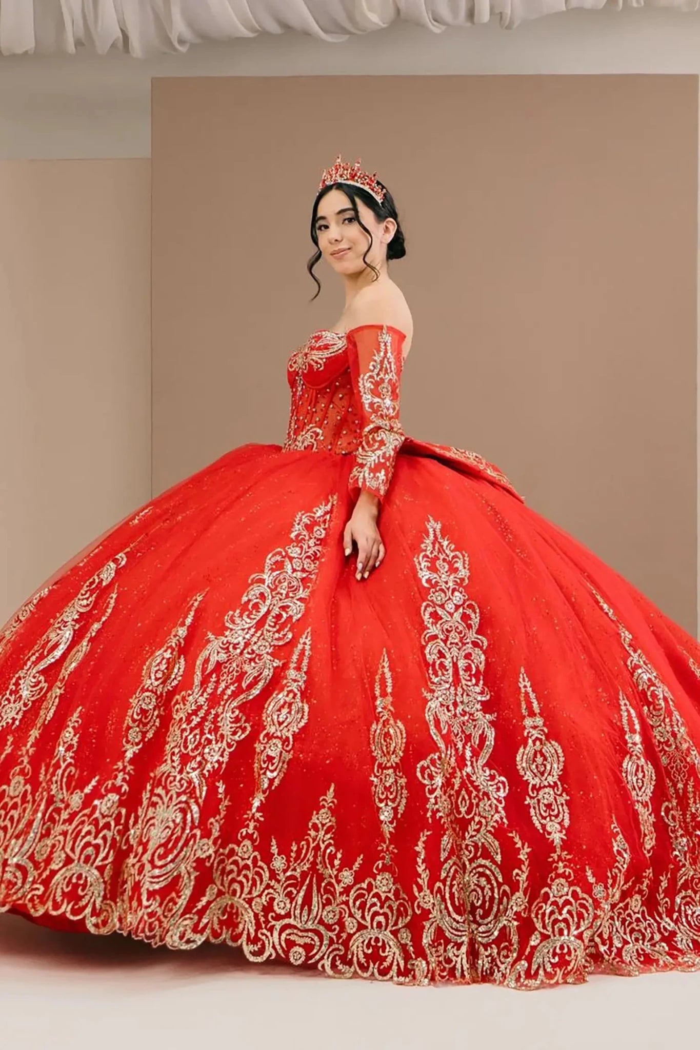 Side close-up view of a woman wearing red quinceañera dress highlighting glitter tulle layers, embroidered bodice, and corset silhouette.