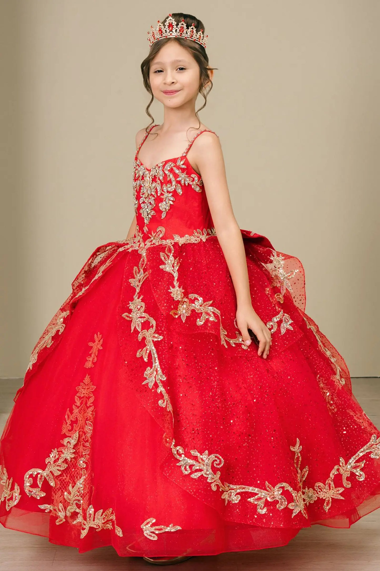 Side close-up view of a red kids quinceañera dress highlighting layered tulle skirt, embroidered bodice, and floral appliques.
