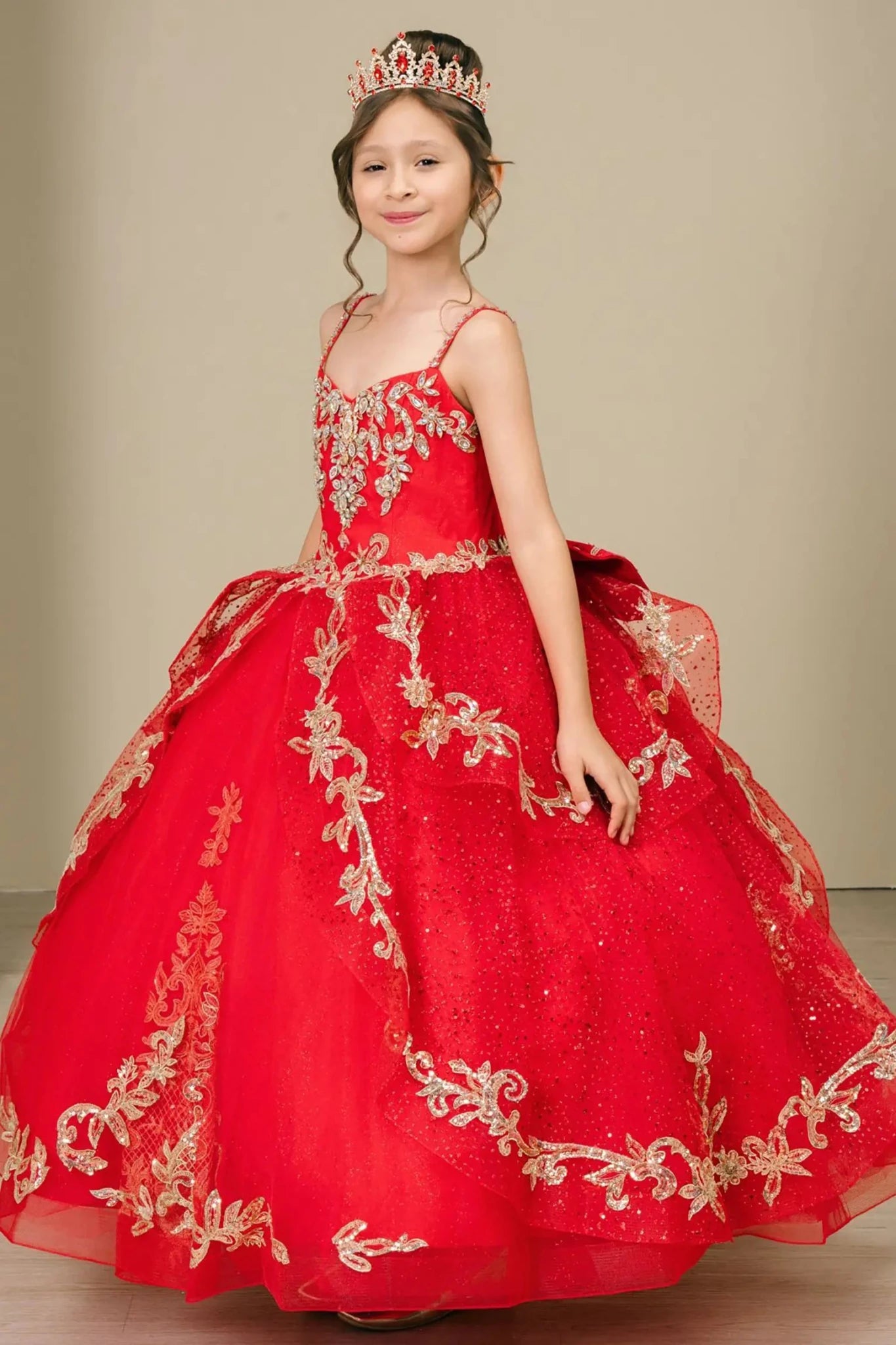 Side close-up view of a red kids quinceañera dress highlighting layered tulle skirt, embroidered bodice, and floral appliques.