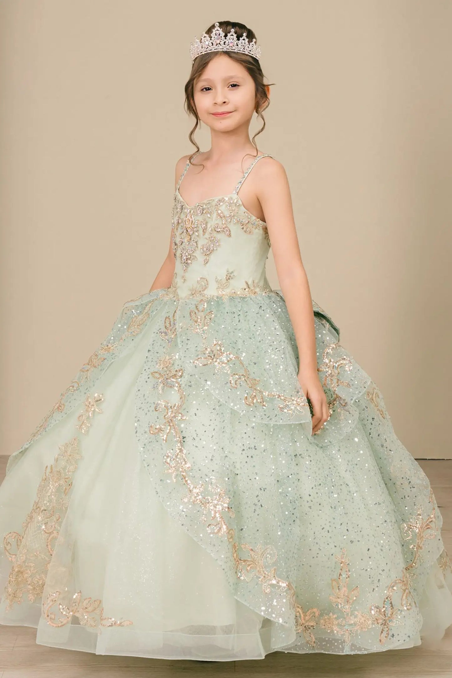 Side close-up view of a sage kids quinceañera dress highlighting layered tulle skirt, embroidered bodice, and floral appliques.