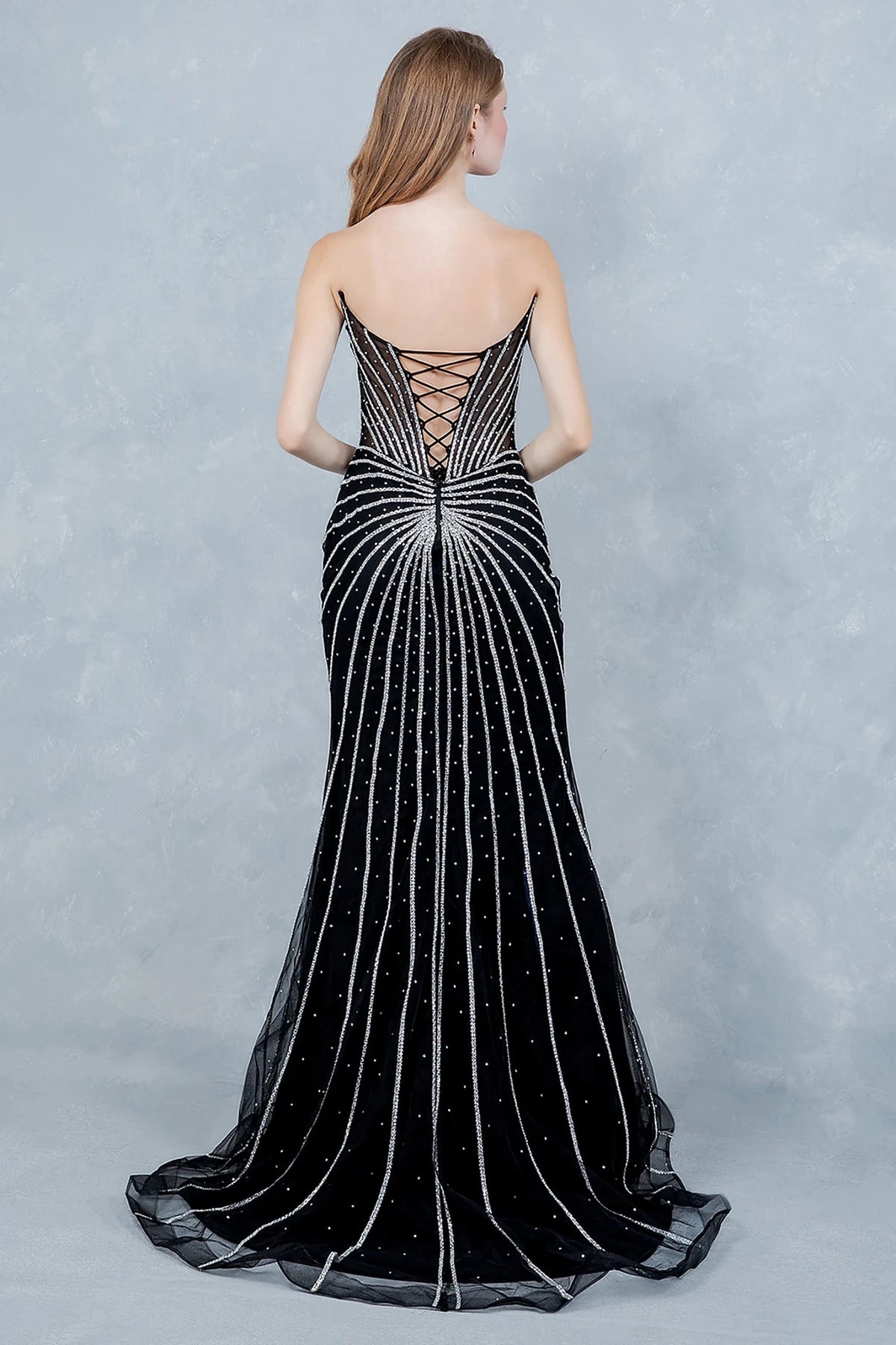 Black evening gown showcasing sunburst pattern extending across structured bodice and lace back up