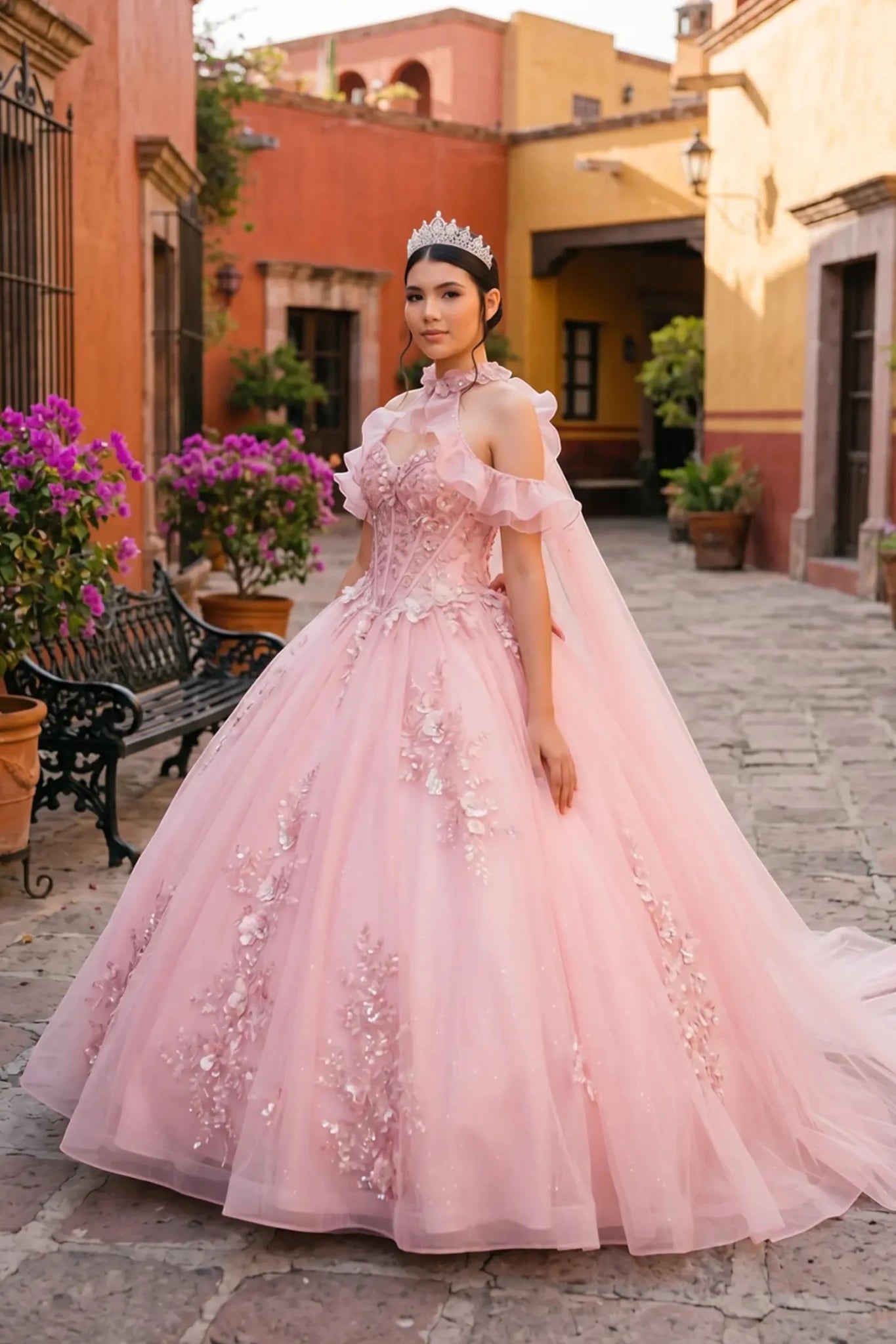 Full front view of a woman wearing pink quinceañera dress with glitter tulle skirt, off-shoulder ruffled sleeves, and beadwork corset bodice.