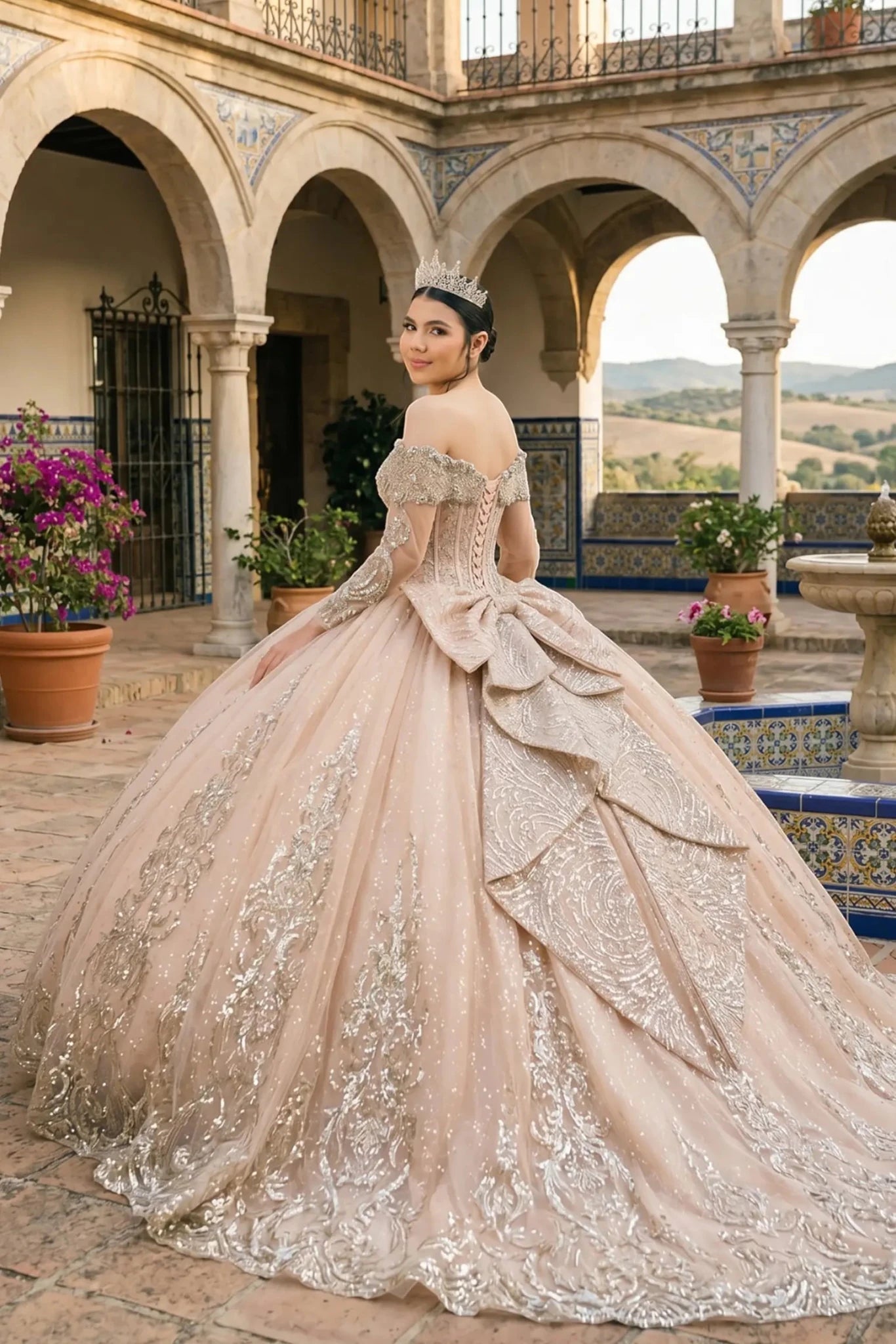 Back view of a woman wearing rose gold quinceañera dress with voluminous tulle skirt, lace-up corset fit, and floral applique embellishments.