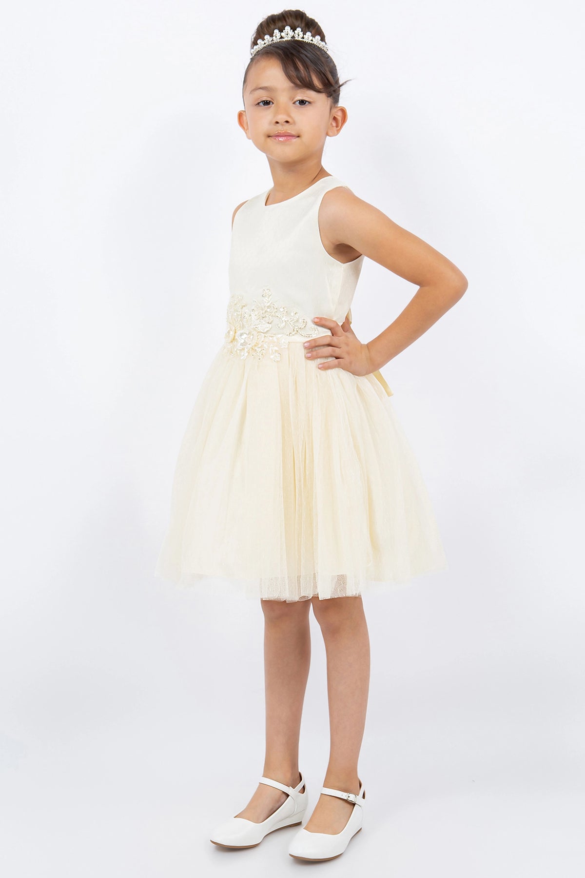 Details of the Champagne flower girl dress include flowers at the waist above the flared skirt.