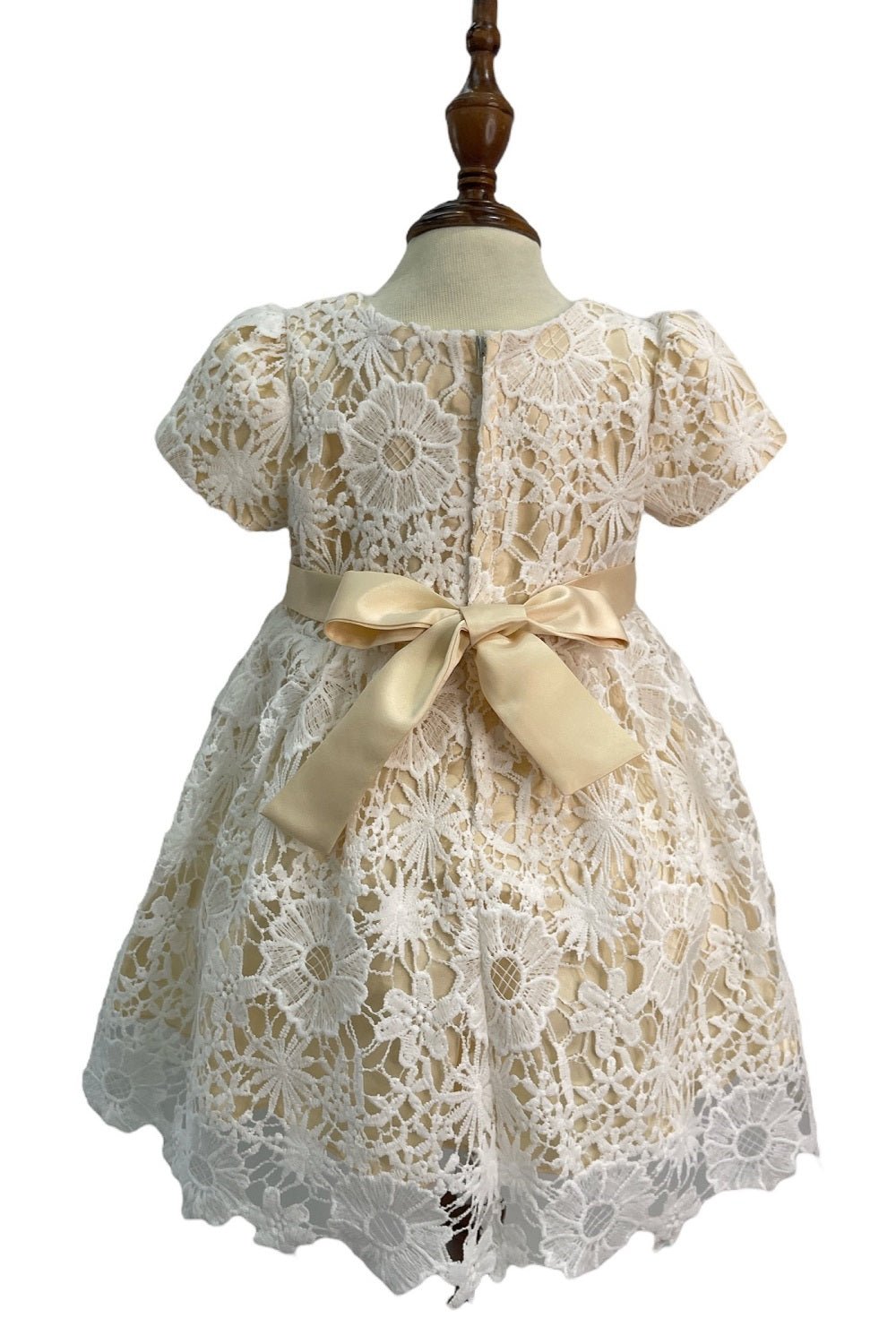 Champagne flower girl dress back view highlighting full skirt and elegant silhouette.