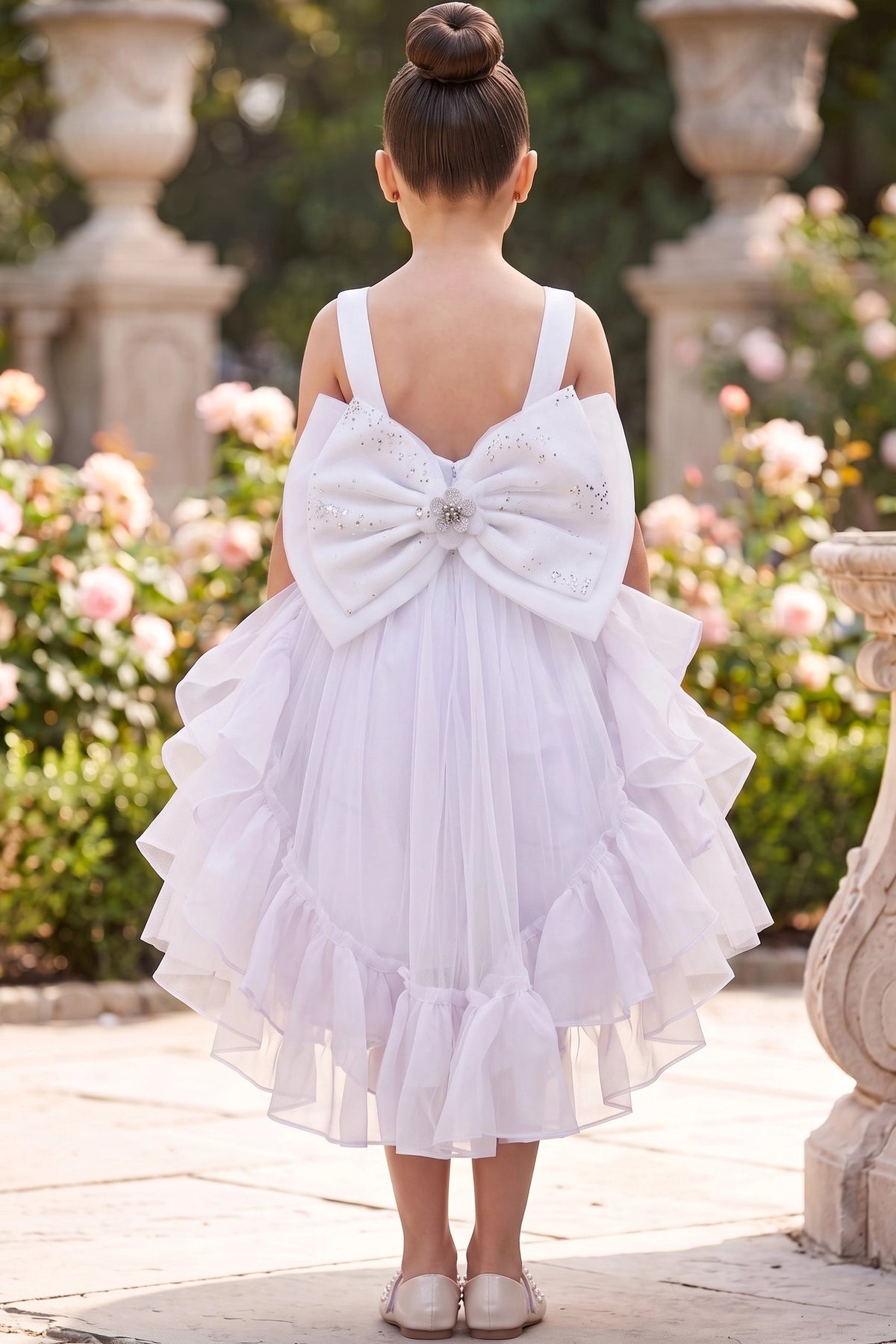 A White flower girl dress showing large satin back bow with beaded center.
