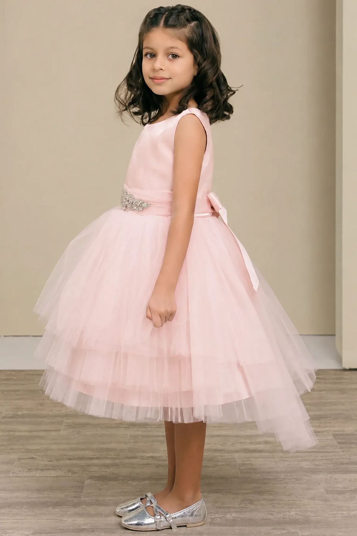 Blush flower girl dress with satin bodice, rhinestone waistband, satin bow back, and layered tulle skirt.