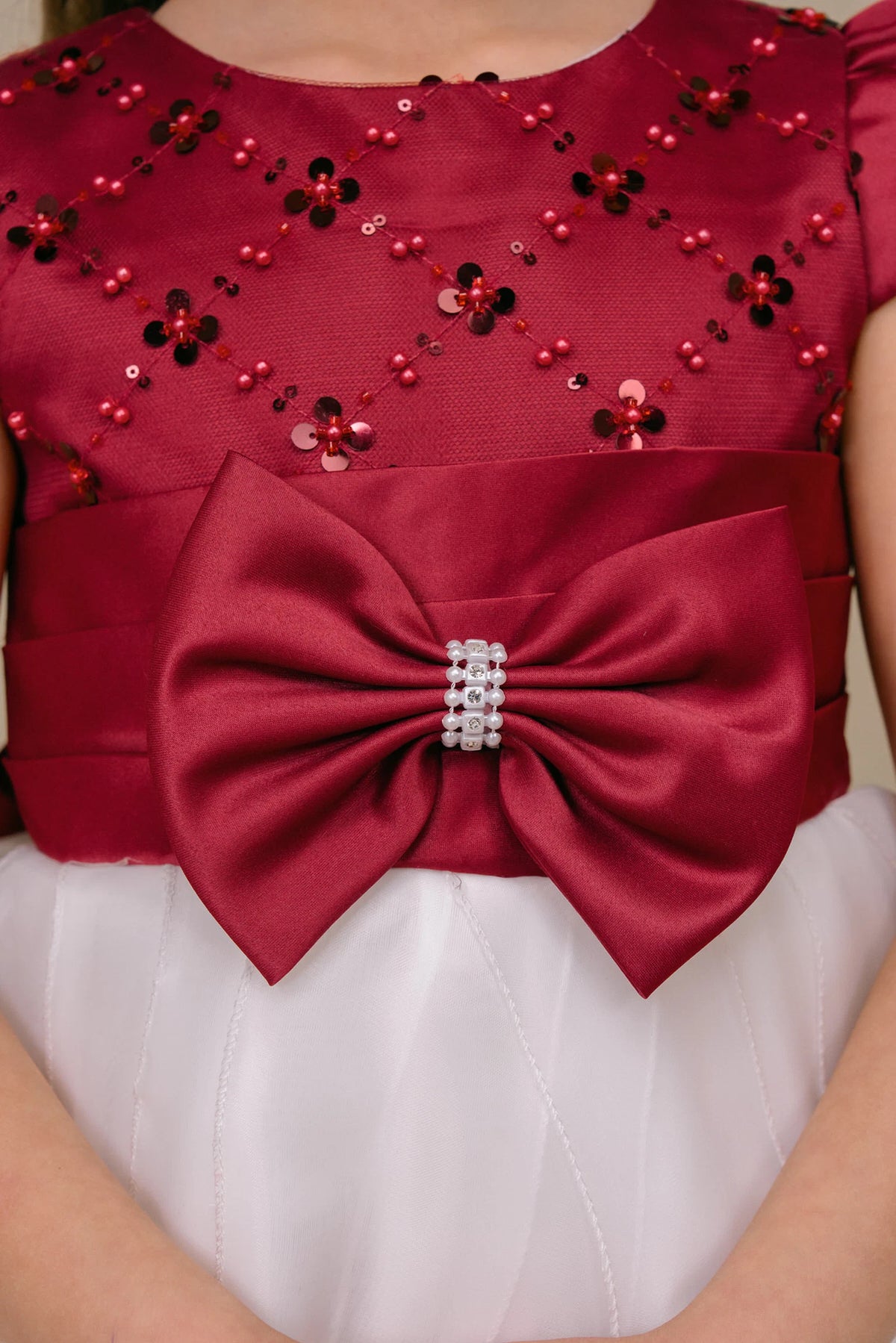 Floral sequins and a sparkling bow detail the Burgundy/Ivory kids party dress bodice.