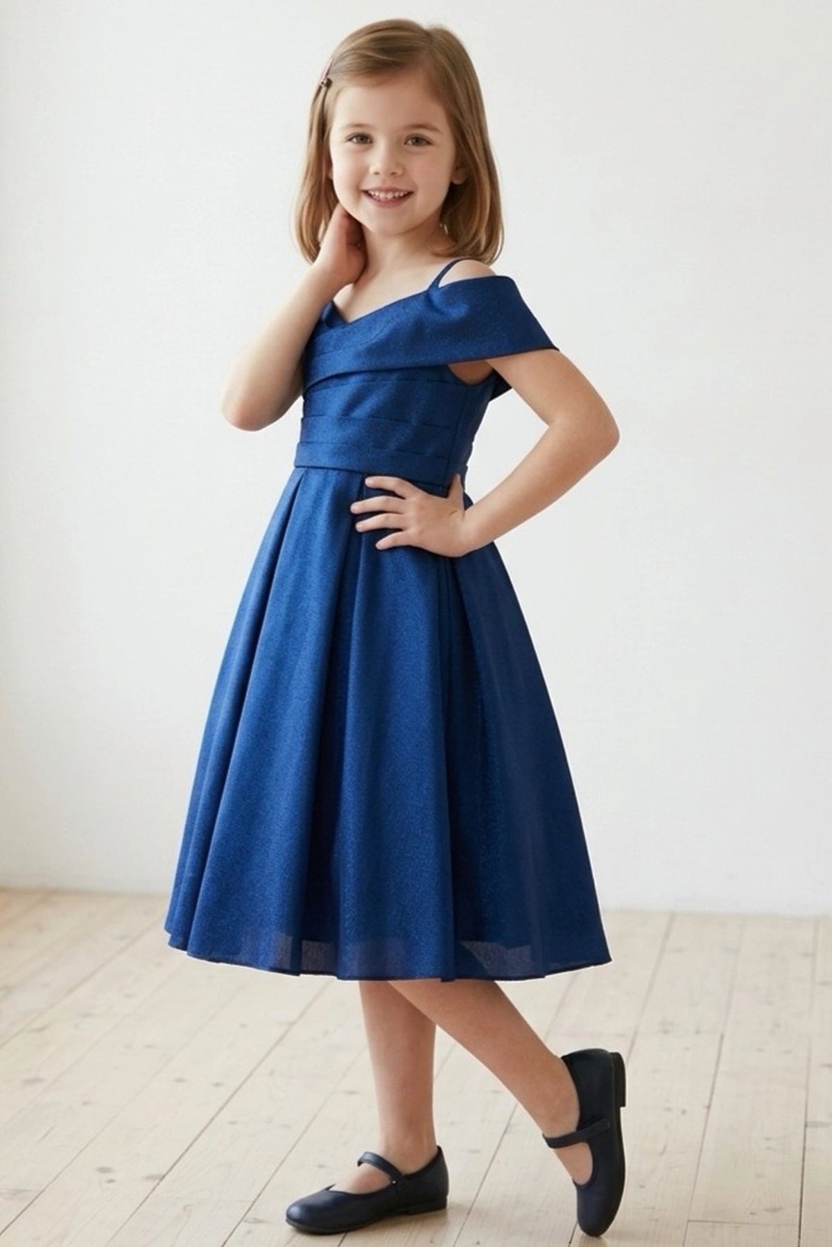 Detailed by a ruched waist band, the Navy kids party dress reveals its construction.