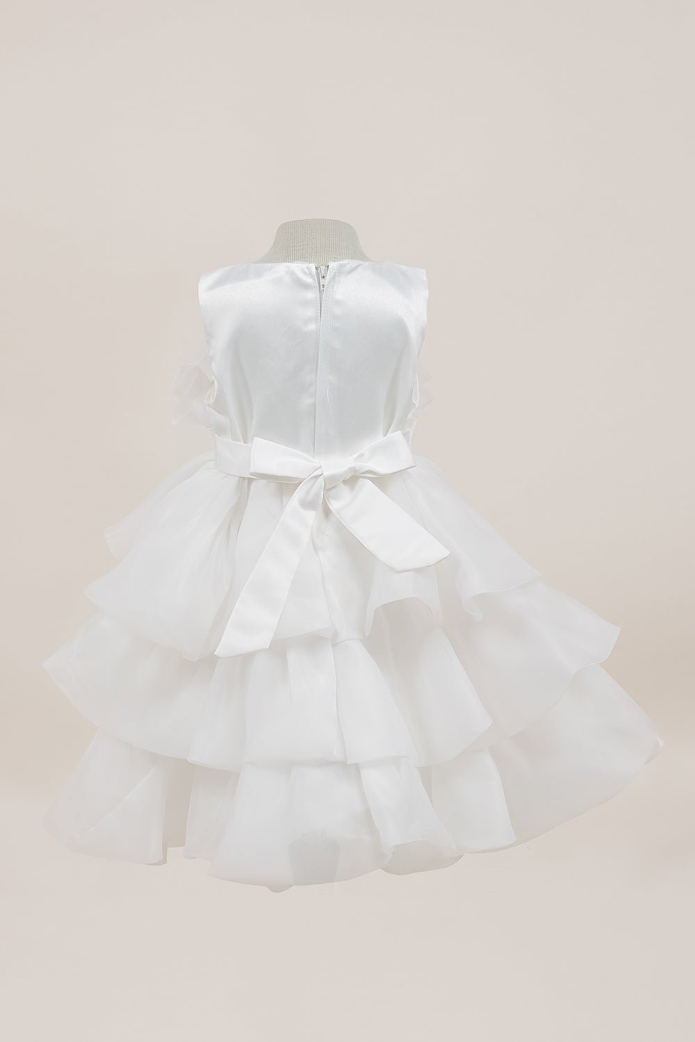 White flower girl dress back view highlighting full skirt and elegant silhouette.
