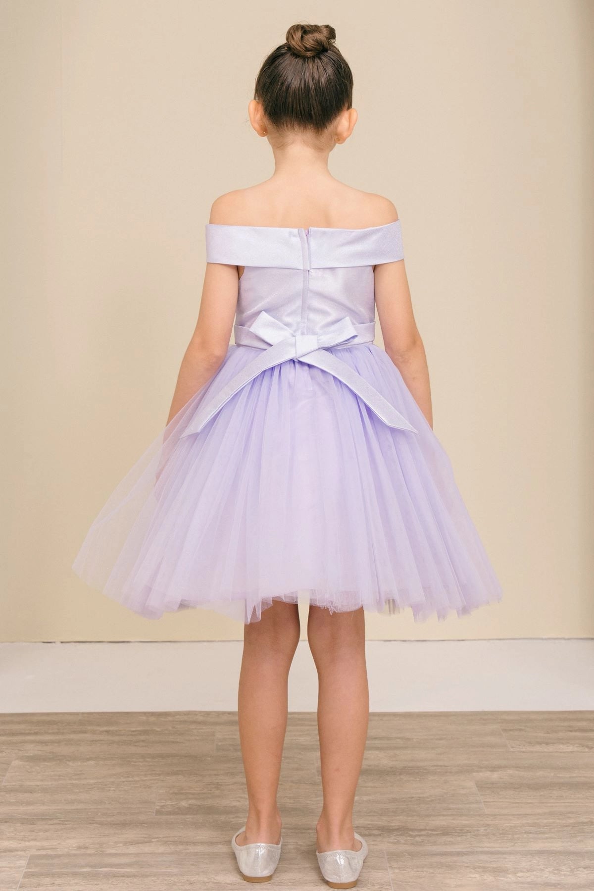 A Lilac flower girl dress showing satin bow and zipper at the back.