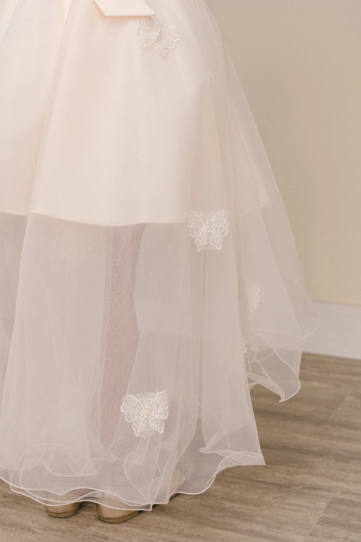 Designed details of three-dimensional bodice flowers distinguish the Champagne kids party dress.