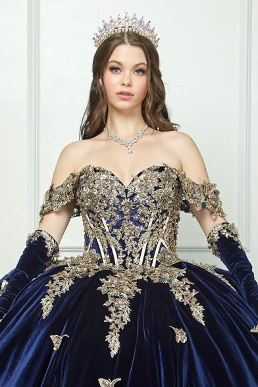 Navy Quinceanera | Off-shoulder Velvet Sweetheart Gold Sequin sequin butterfly floral Ballgown with Sweep train - zoomed in front view of woman wearing dress and crown