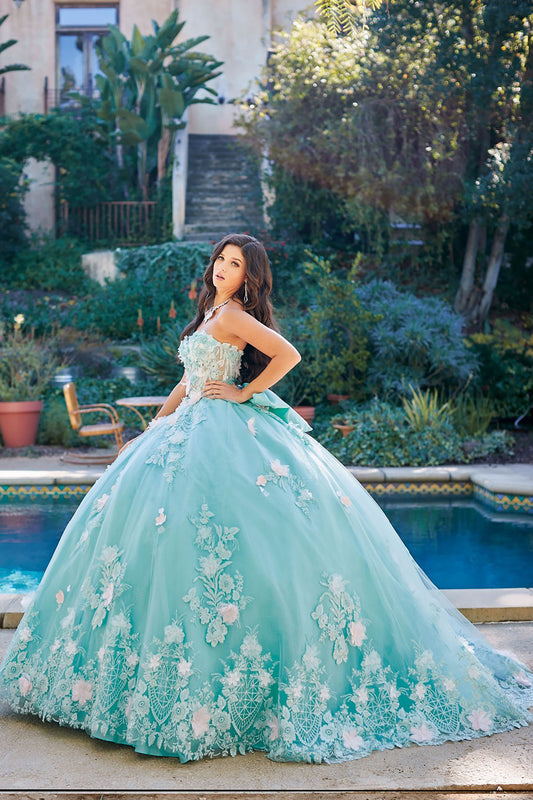 Quinceanera | Mint See-through 3D Flowers, Embroidery, Bead bodice and Glitter Tulle Ballgown w/ detachable Big Bow - side view of woman wearing dress with one hand on hip