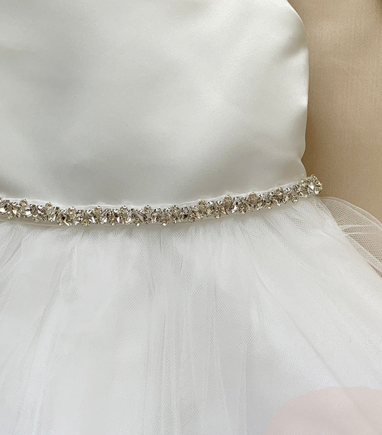 White dress with a decorative belt on a neutral background