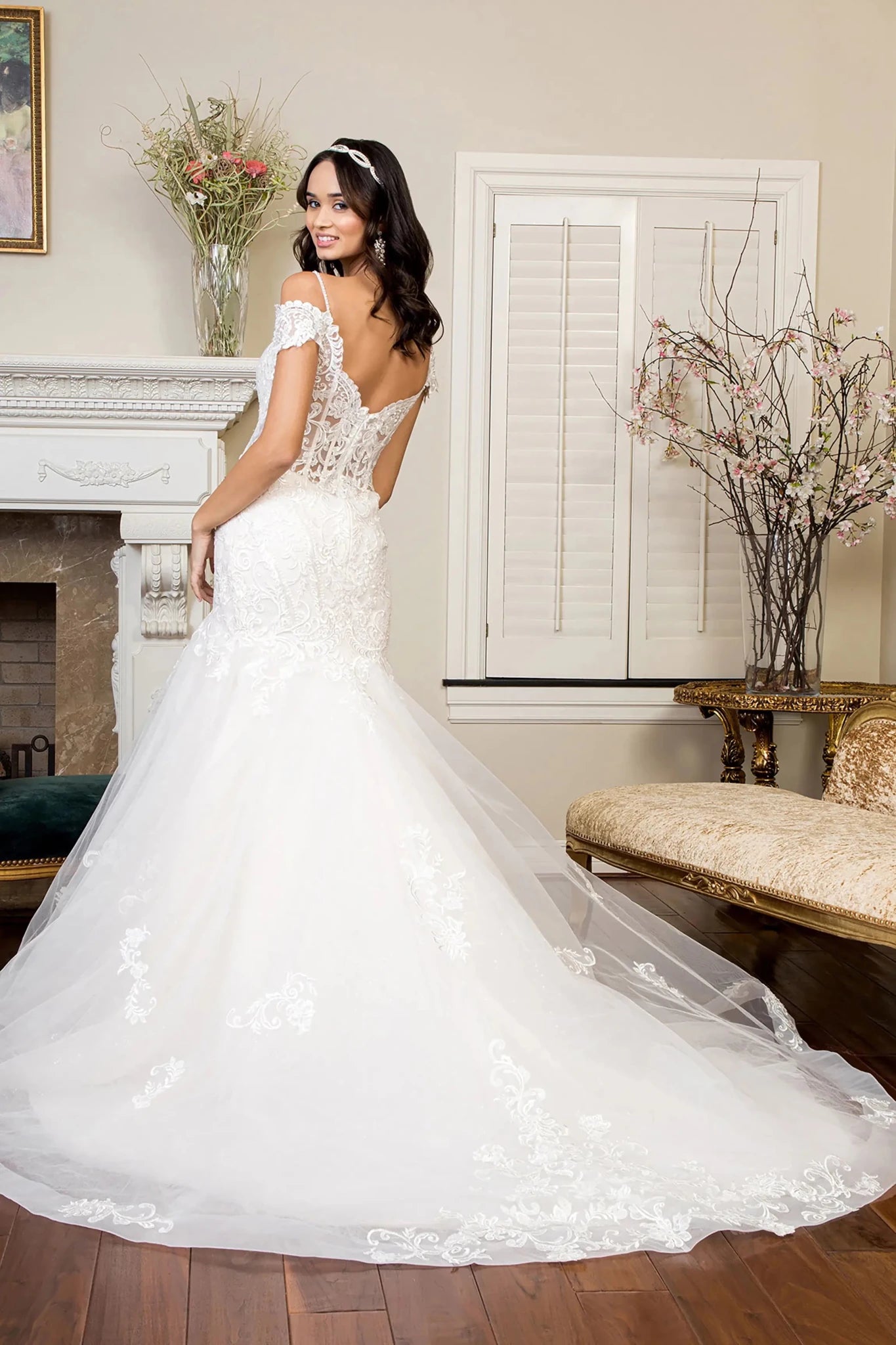 Back full-length view showcasing the dramatic transition from the contoured hips to the flared mermaid hem and the graceful sweep of the ivory fabric.
