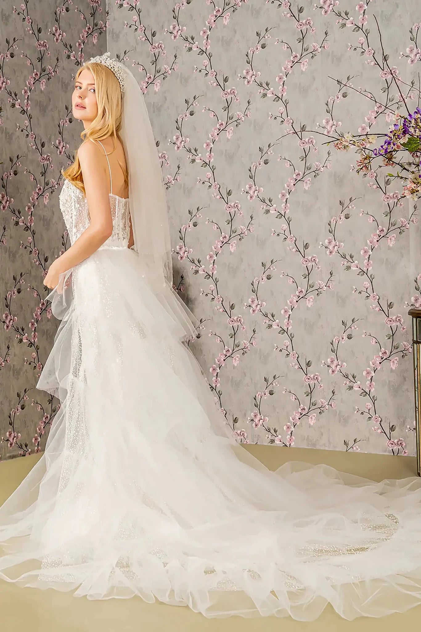 Back full-length view showcasing the dramatic flared mermaid silhouette and the ethereal sweep of the long ivory mesh cape as it extends past the bridal train.