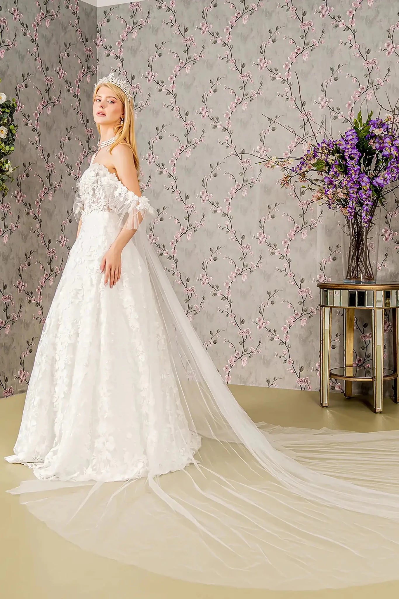 Back full-length view showcasing the regal silhouette of the ball gown and the dramatic sweep of the sheer drape as it blends into the expansive embroidered train.