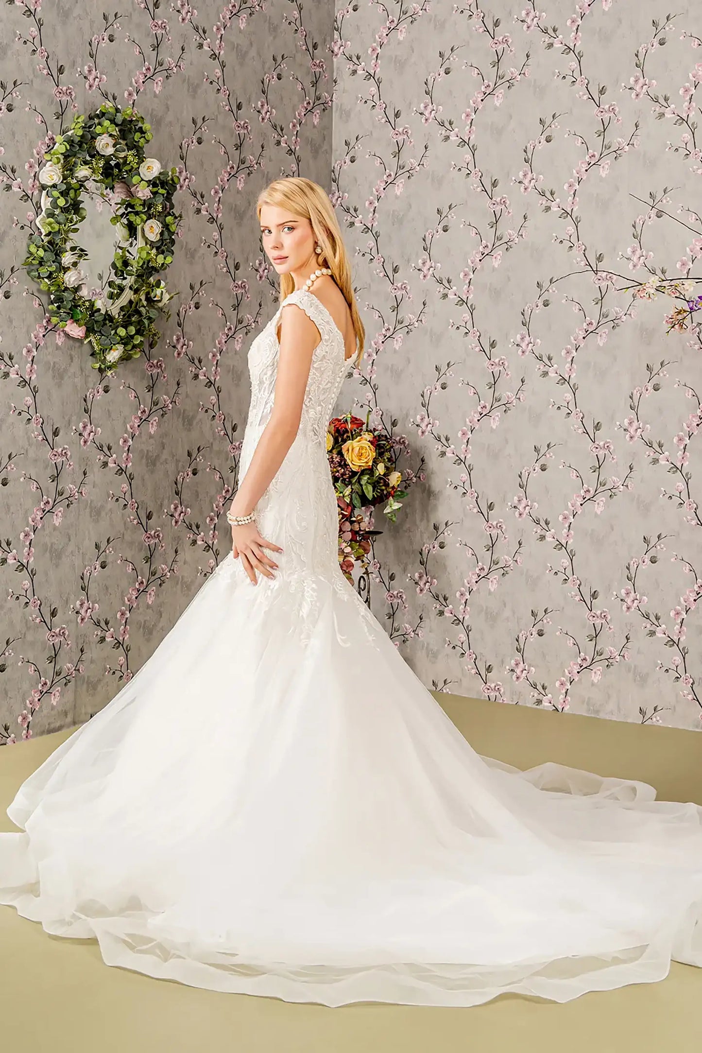 Back full-length view showcasing the sleek trumpet silhouette and the expansive sweep of the train, featuring cascading floral lace motifs and sparkling sequin details.