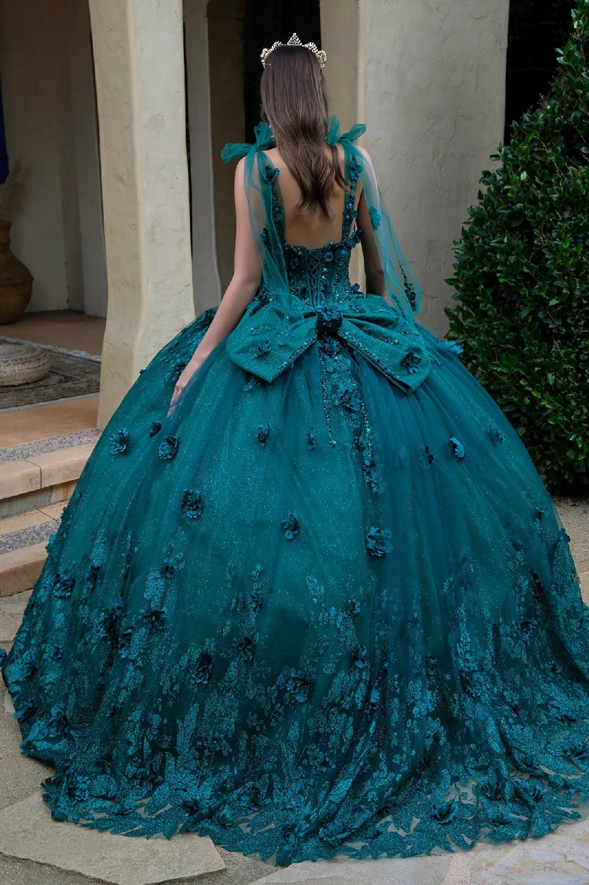 Back detail shows green quinceañera dress with floral appliques glitter underlayer structured bodice tulle gown.