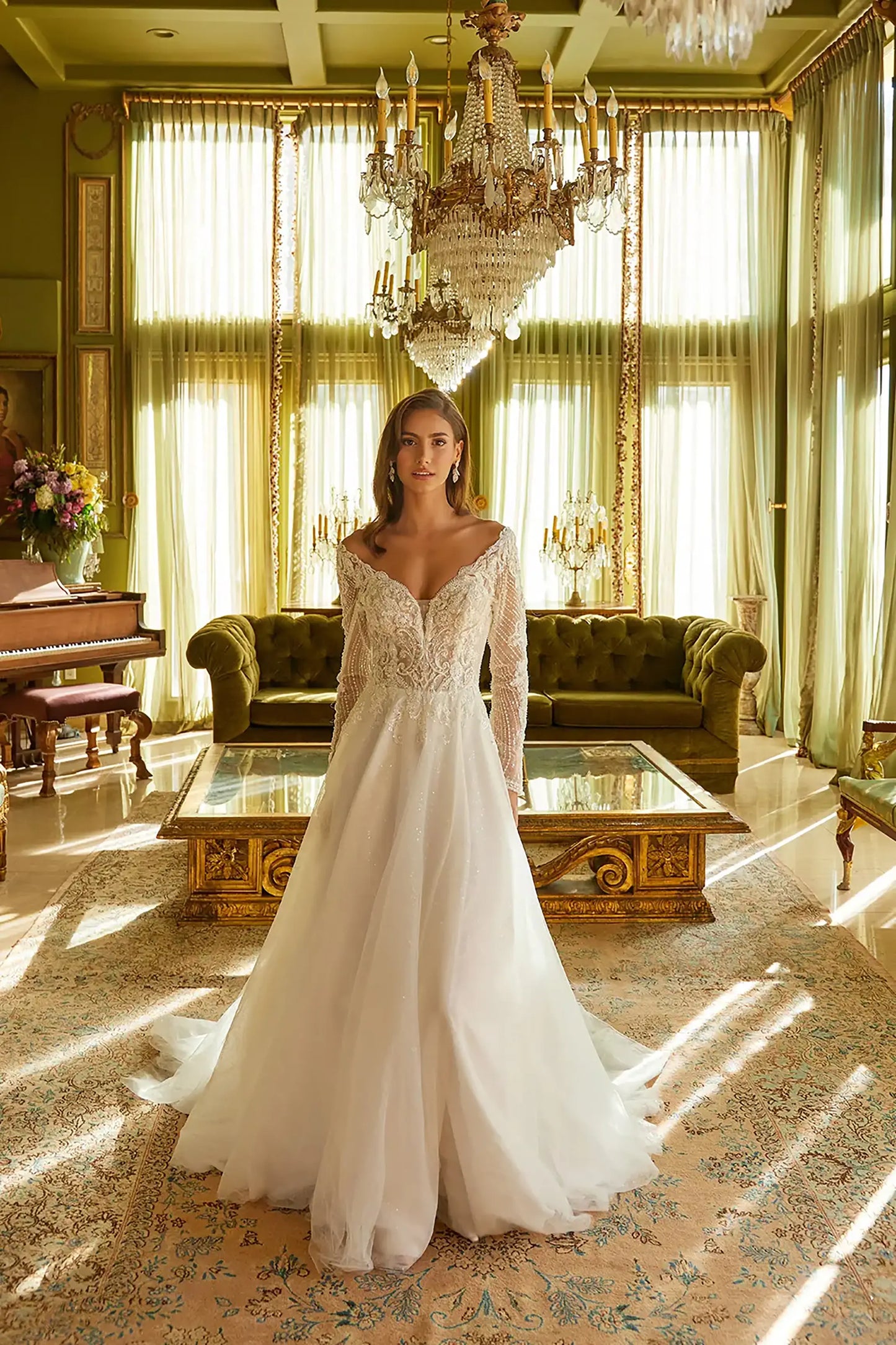 Front full-length view of Off White A-line wedding dress with wide front V-neckline, deep V-back, long embellished sleeves, hidden sequined mesh skirt, and flowing train