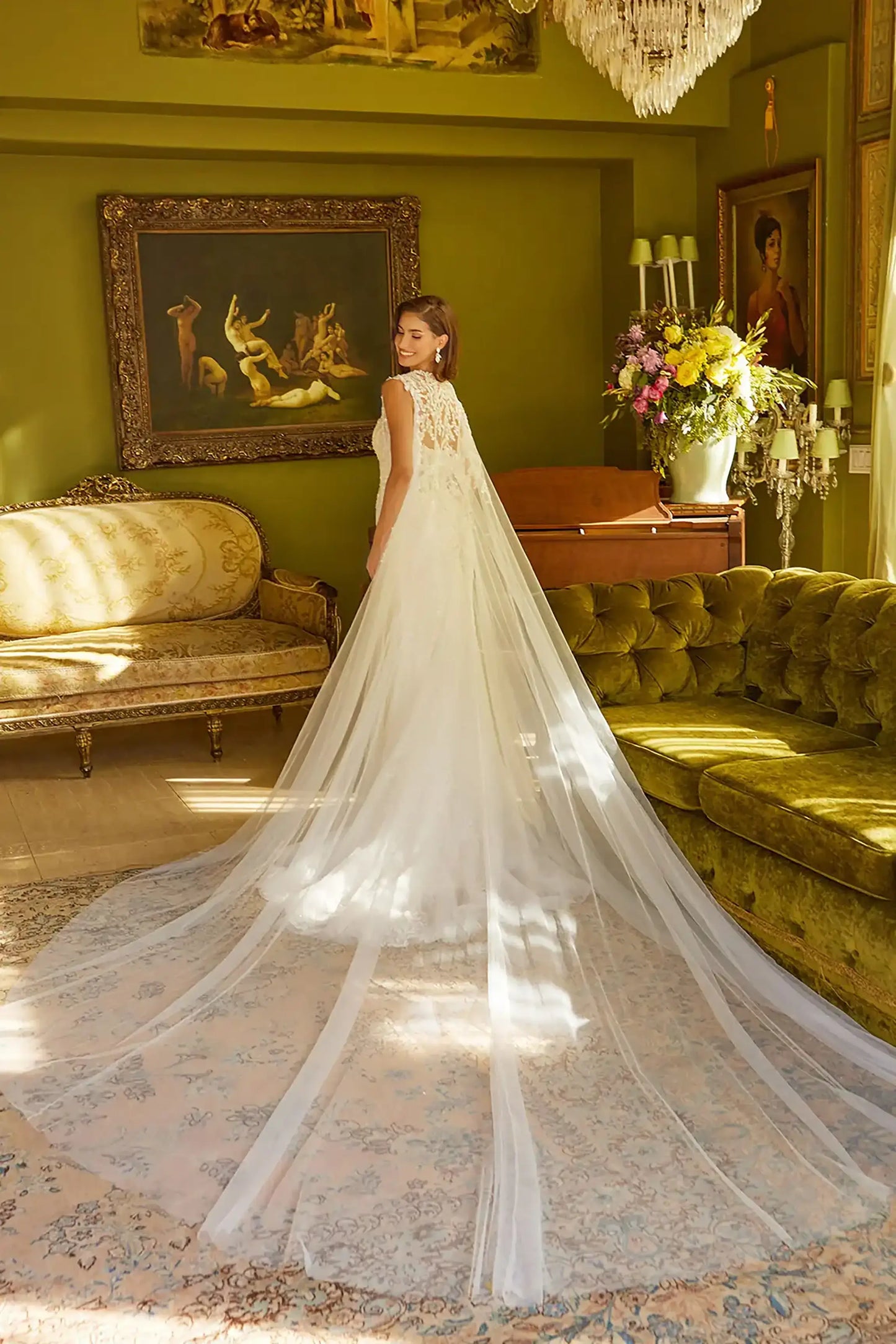 Back full-length view of Off White trumpet wedding dress with V-neck corset bodice, spaghetti straps, beaded embroidery, sequins, floral lace underlayer, zipper back, and matching cape train