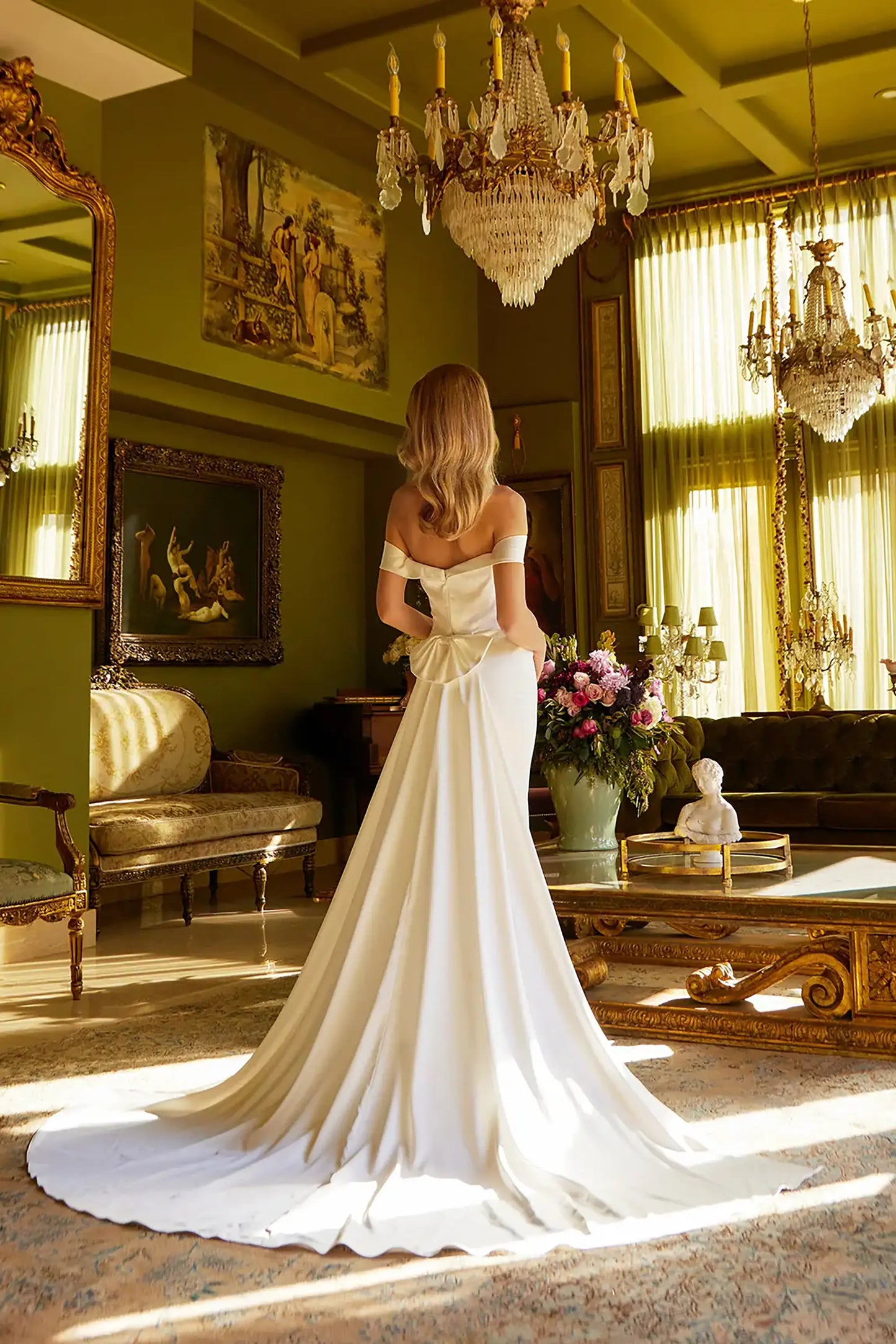Back full-length view of Ivory fitted satin wedding dress with sweetheart neckline, off-shoulder straps, side-gathered pleats, slit skirt, and detachable back bow with train