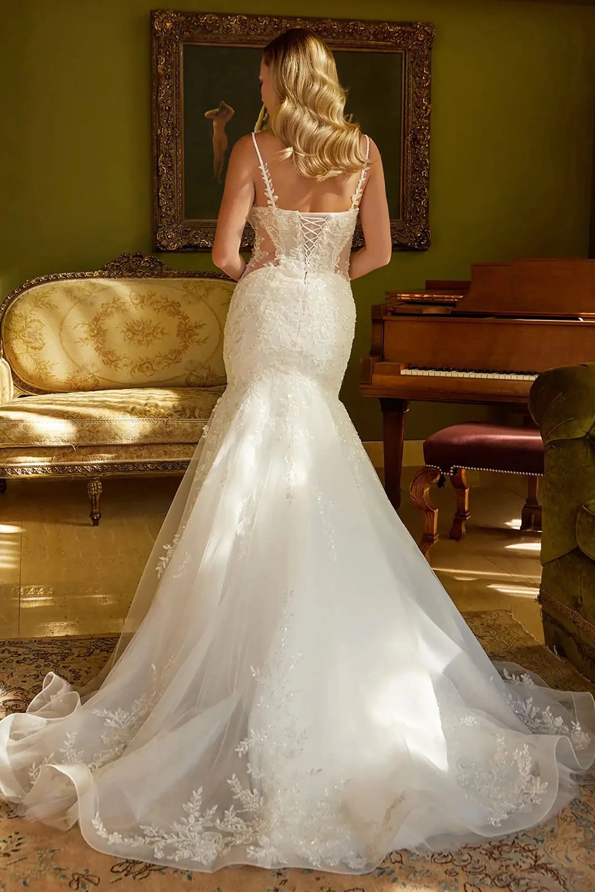 Rear view reveals Off White wedding dress with the dramatic flared mermaid silhouette and the crisp.
