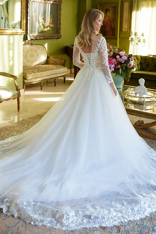 Back full-length view showcasing the elegant sweep of the skirt and the ornate scalloped detailing along the hem of the bridal train.