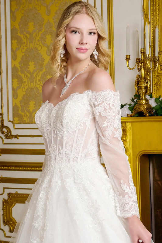 Woman wearing a white lace dress in an elegant room with gold accents.