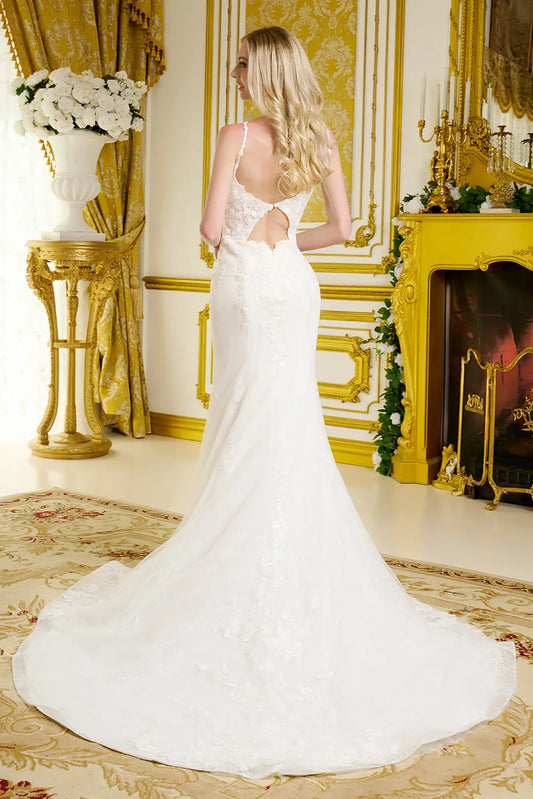 Woman in a white wedding dress standing in an opulent room with gold decor.