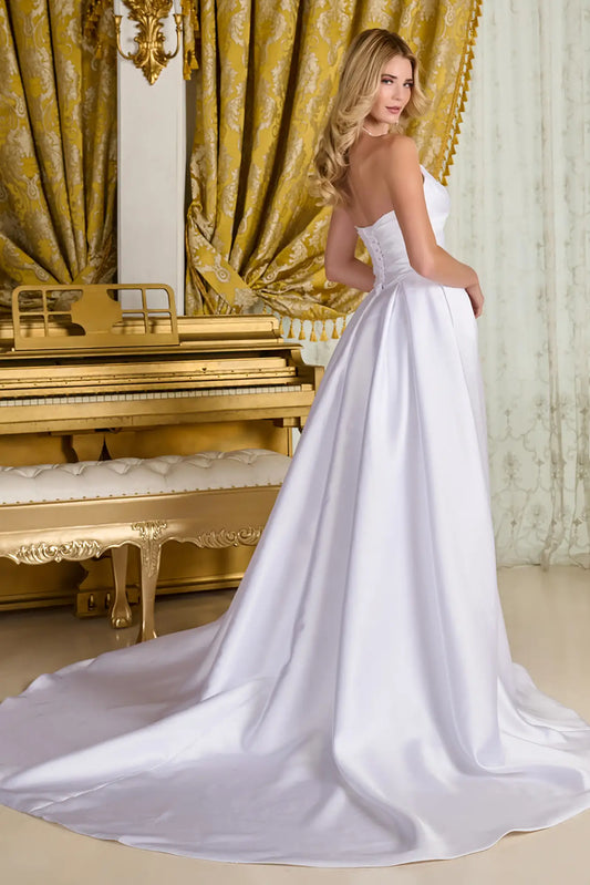 Woman in a wedding gown standing beside a golden piano