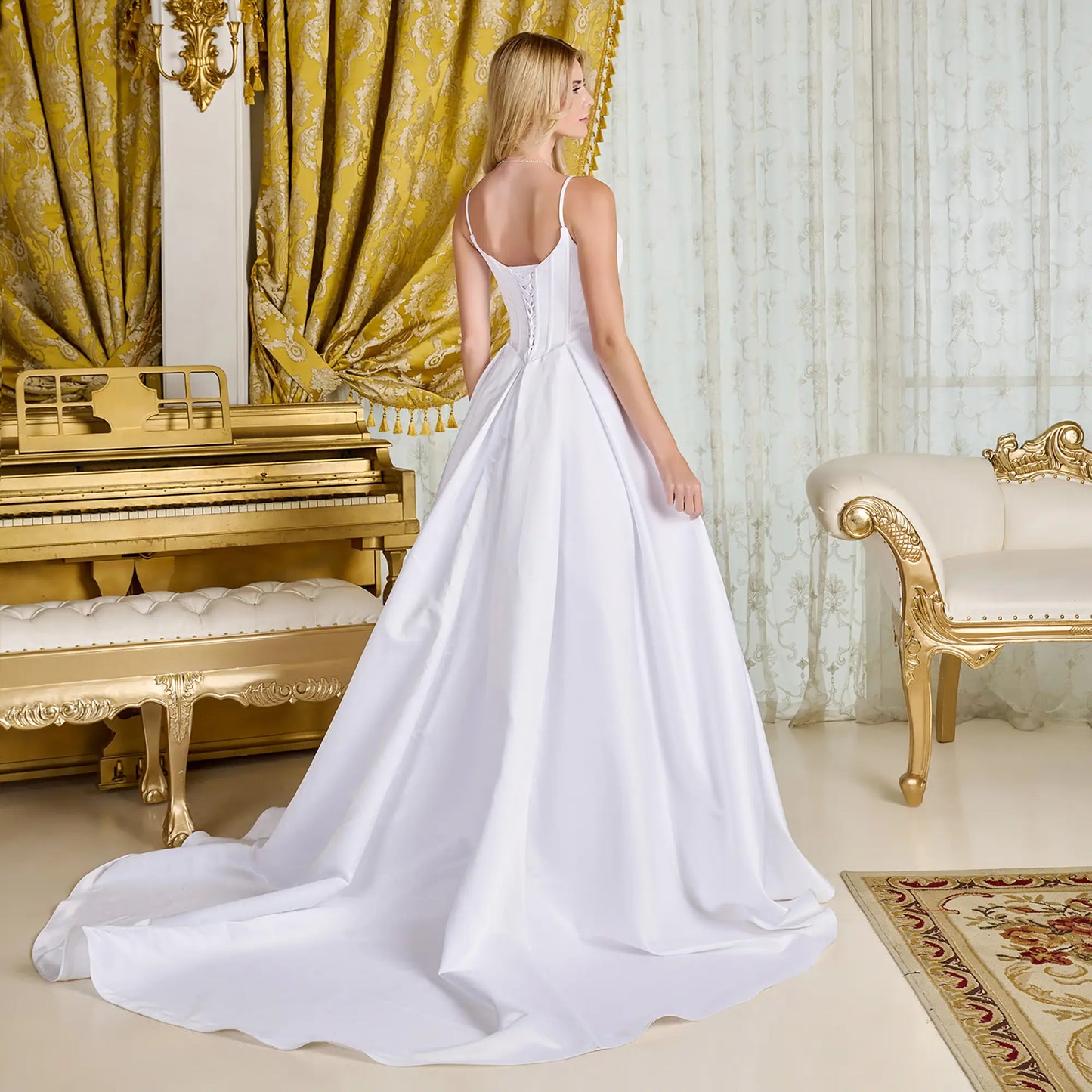 Woman wearing a wedding gown in a elegant room with gold piano