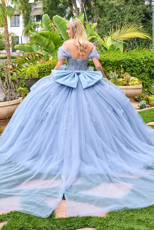 Back view of dusty blue quinceañera ball gown featuring lace-up corset and oversized bow with flowing tulle skirt