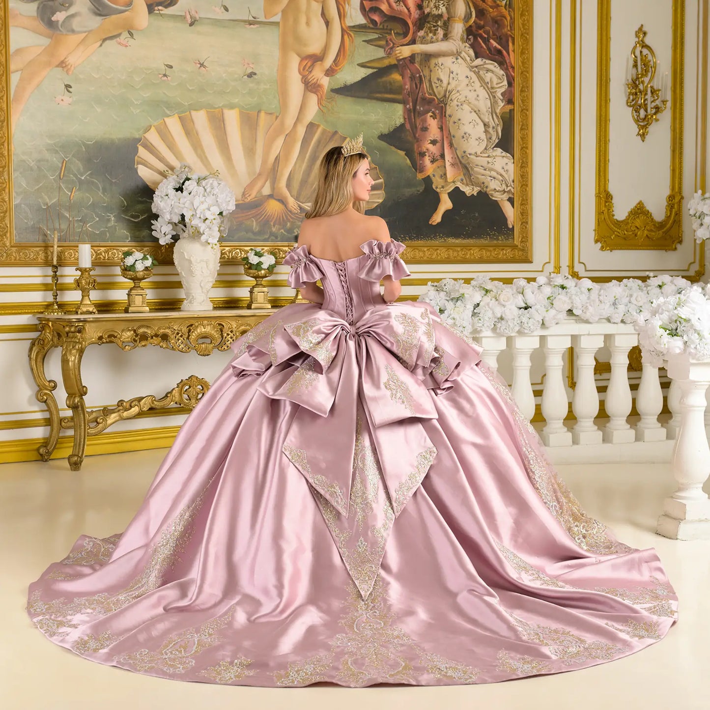 Back view of a woman wearing mauve quinceañera dress with gold embroidery corset bodice peacock feather skirt