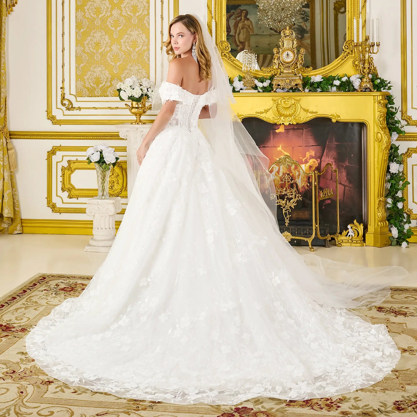 Woman in a white wedding dress standing in an opulent room with gold decor.