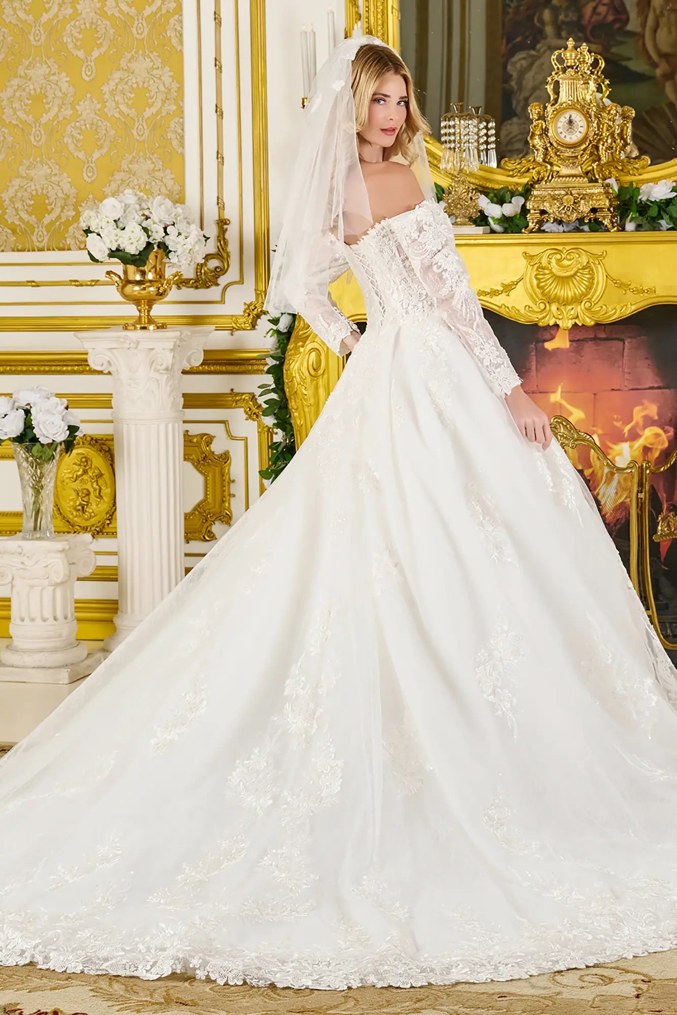 Woman in a white wedding dress standing in an ornate room with gold accents.