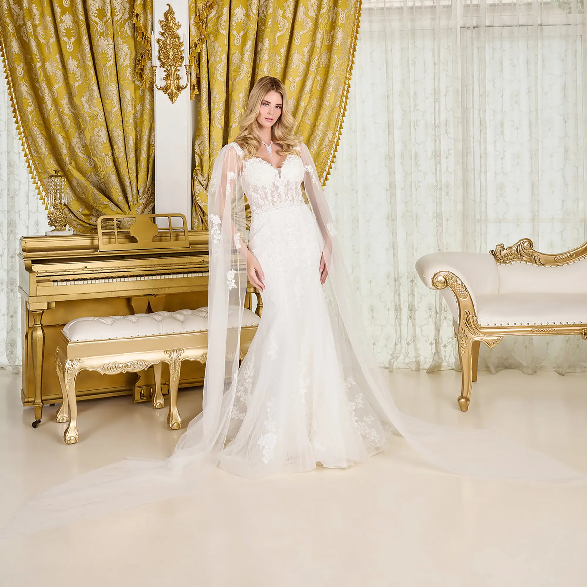 Woman in a white wedding dress standing in an opulent room with gold and white decor.