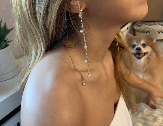 girl wearing a necklace near a dog