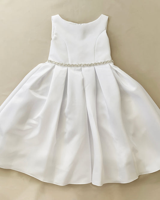 White dress with a beaded waistband on a beige background