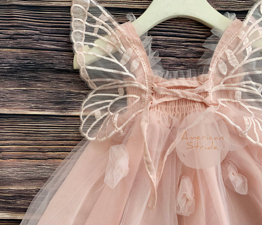 Pink fairy dress with butterfly wings on a wooden surface, brand 'American Stride' visible.