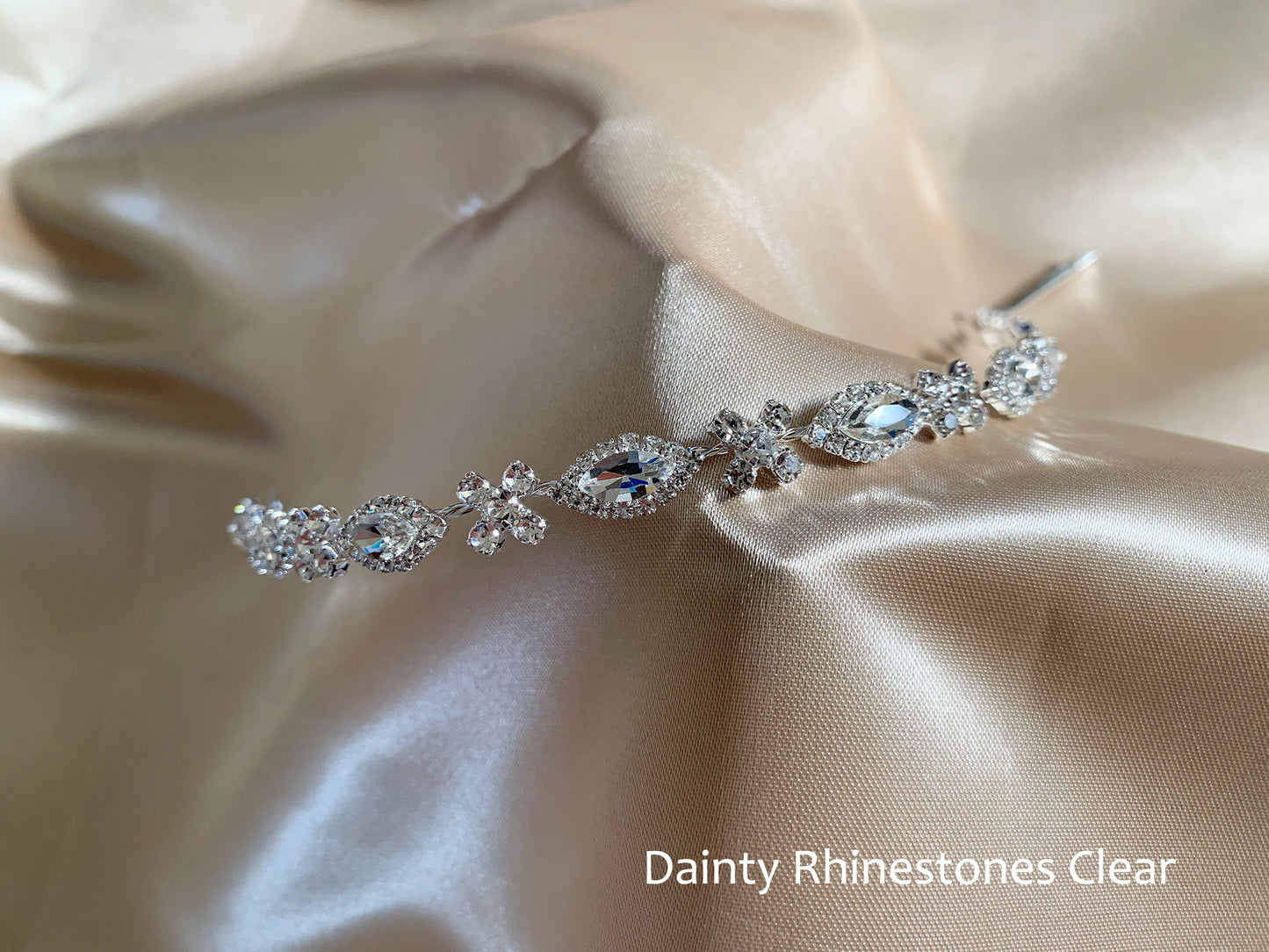 Silver hair vine with clear rhinestones on beige satin fabric