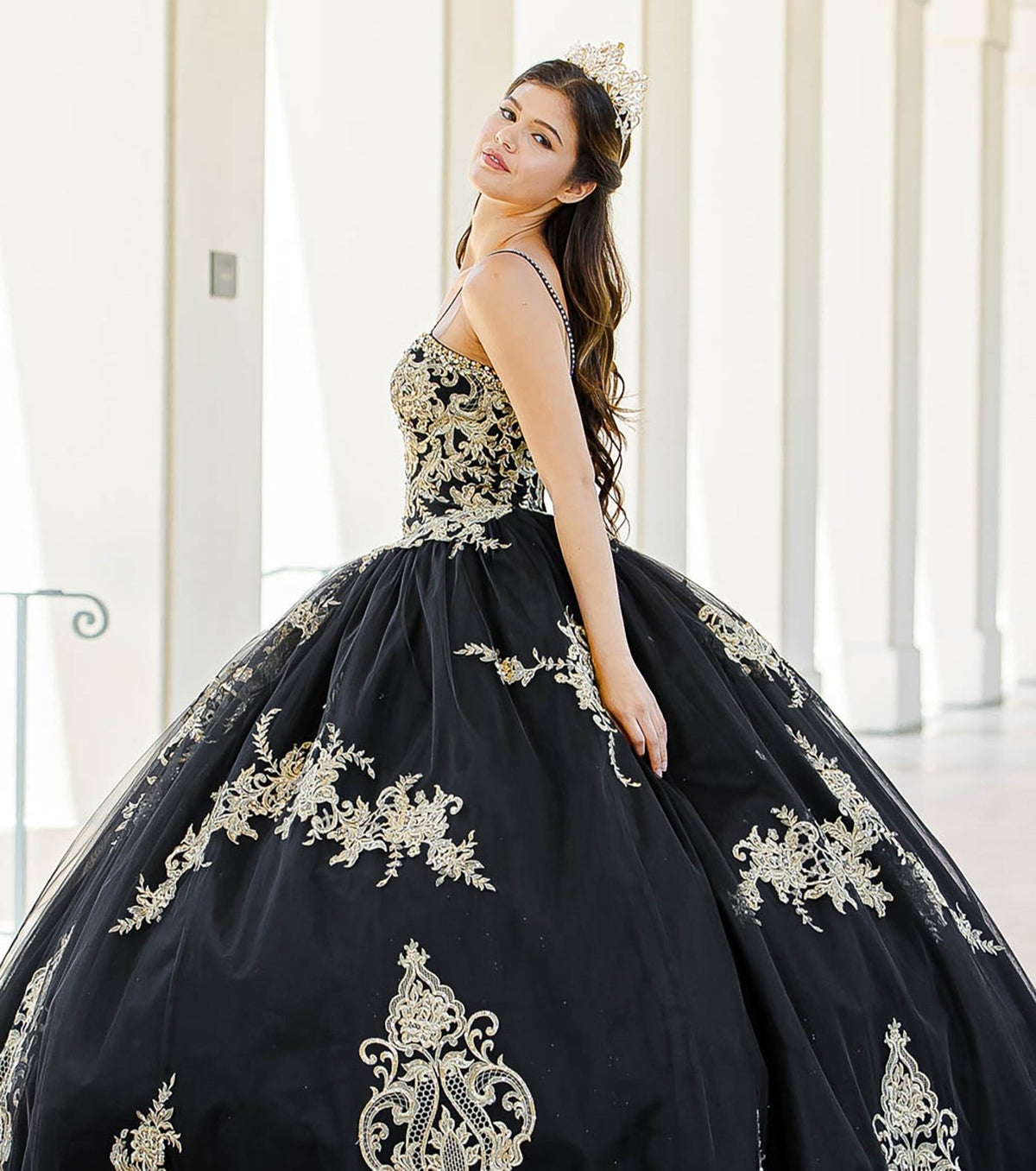Side profile shows a black quinceañera dress with gold embroidered lace, cape and ball gown skirt.